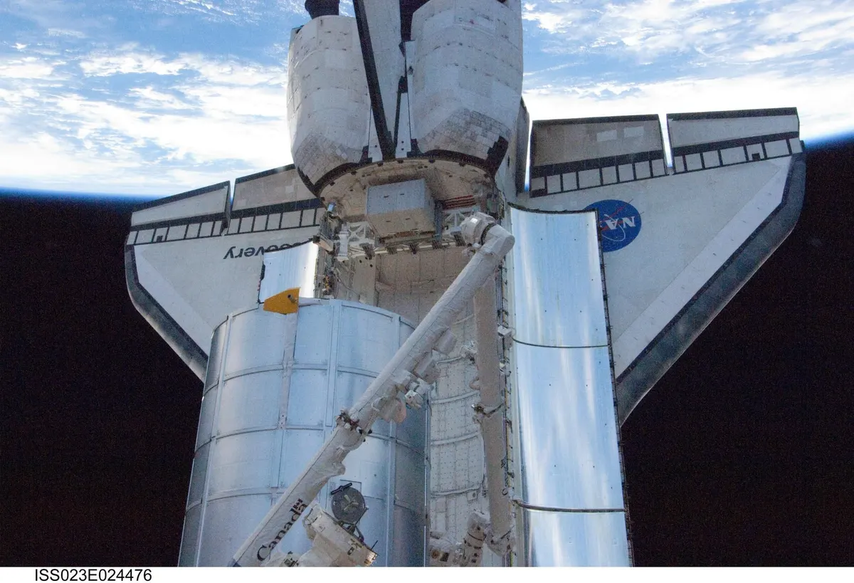 The Leonardo logistics module above the payload bay of Space Shuttle Discovery, seen from orbit
