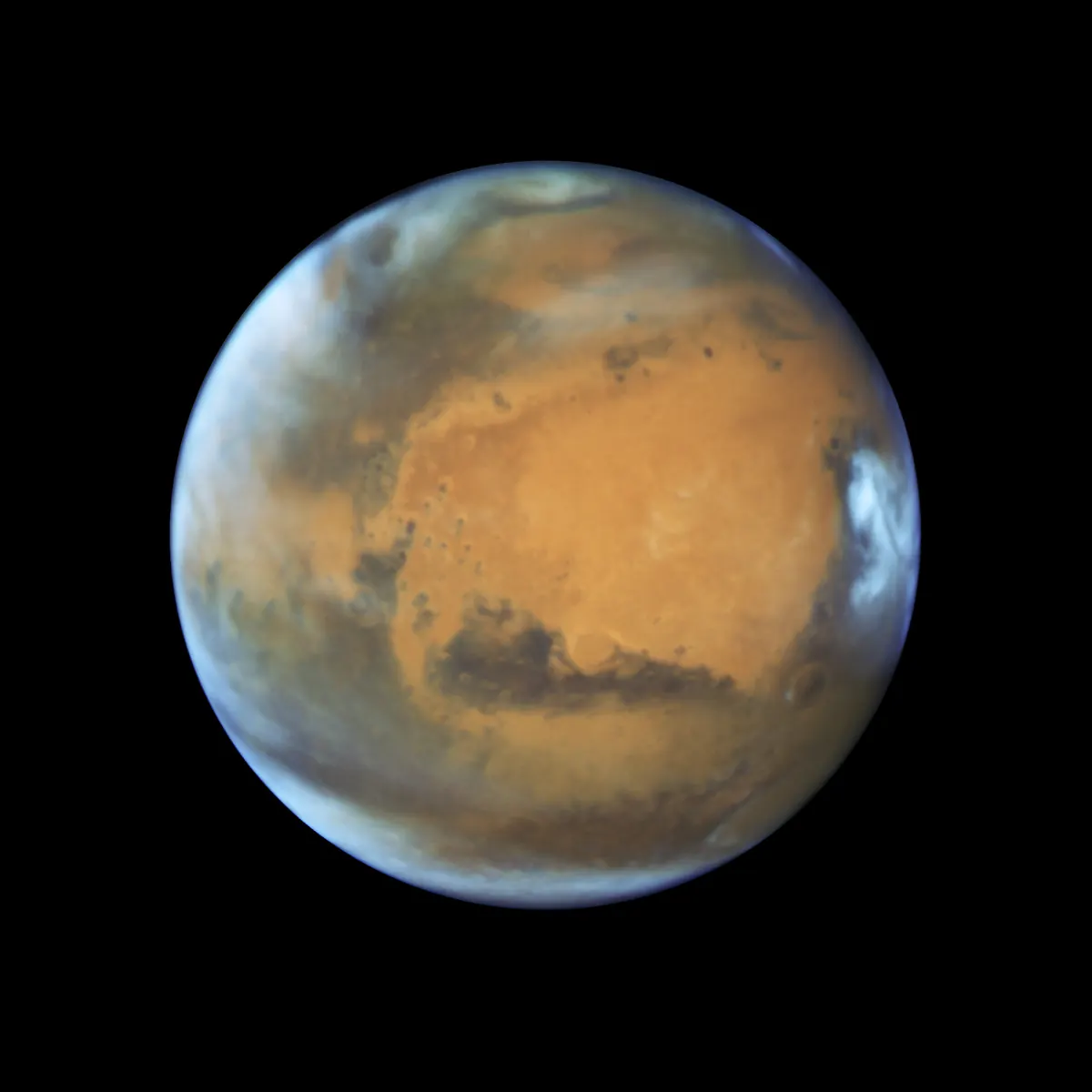 Mars as a rust-orange globe with dark markings and a white polar cap, against black space