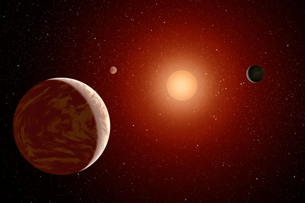 A large red star with three planets of different sizes around it