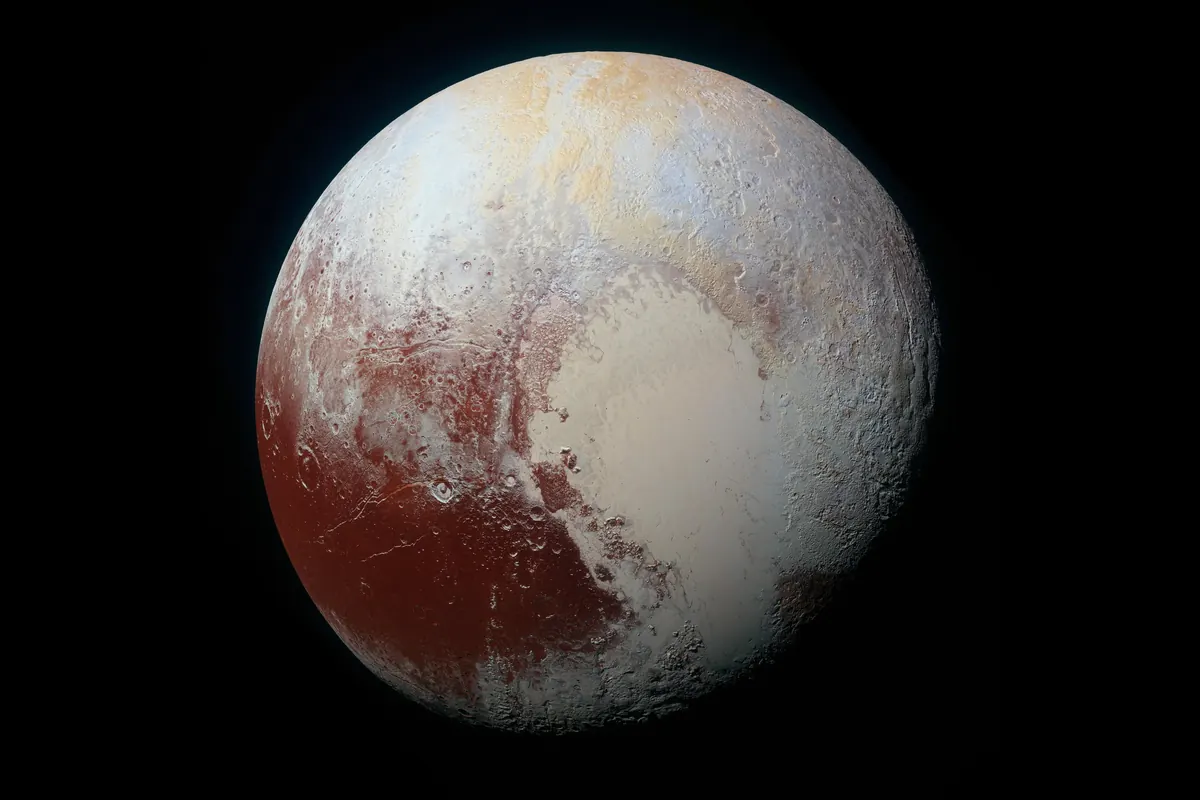 The dwarf planet Pluto in enhanced color, with a pale heart-shaped region and reddish-brown terrain