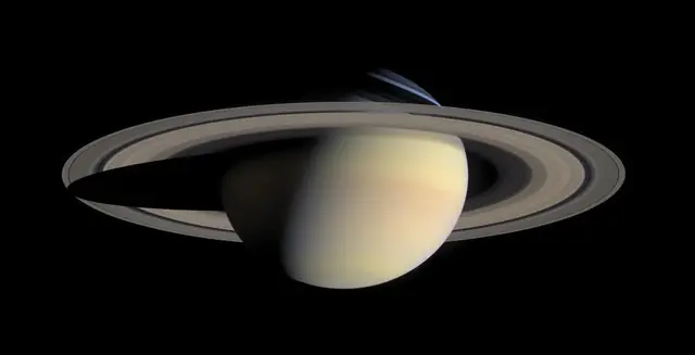 Saturn and its rings in natural color against black space
