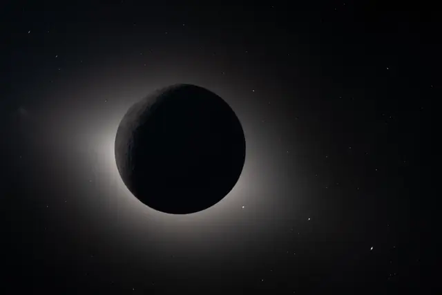 The Sun hidden behind the Moon, with the glowing corona around the black disc and stars in the dark sky