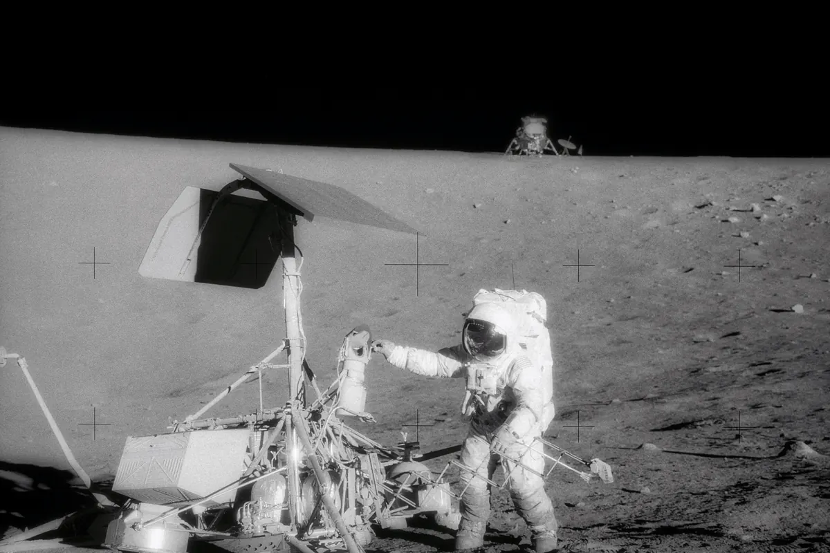 The Surveyor 3 spacecraft on the lunar surface with the Apollo 12 lunar module in the distance
