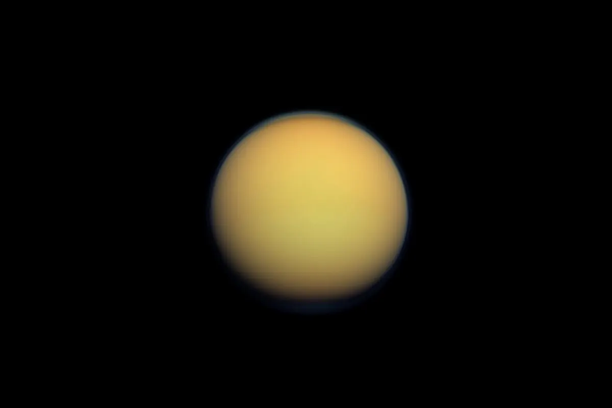 Saturn's moon Titan as a fuzzy orange ball against black space