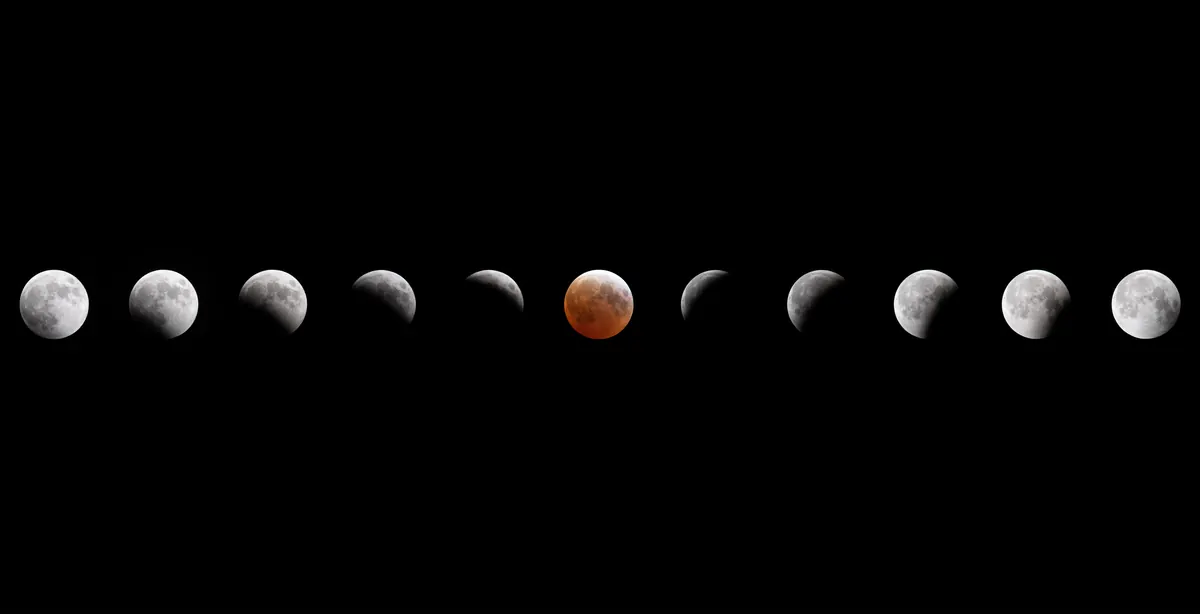 A row of twelve images of the Moon going into and out of Earth's shadow, red in the middle