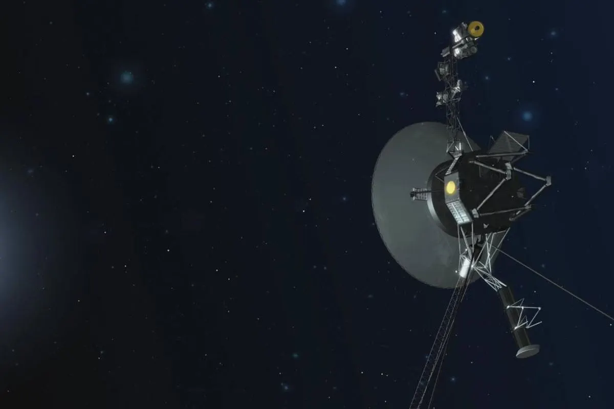 A Voyager spacecraft with its large dish antenna and long boom against dark space
